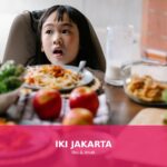 Ilustrasi anak yang susah makan dengan makanan sehat di meja