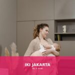 Seorang ibu menyusui bayinya dengan penuh kasih sayang di rumah